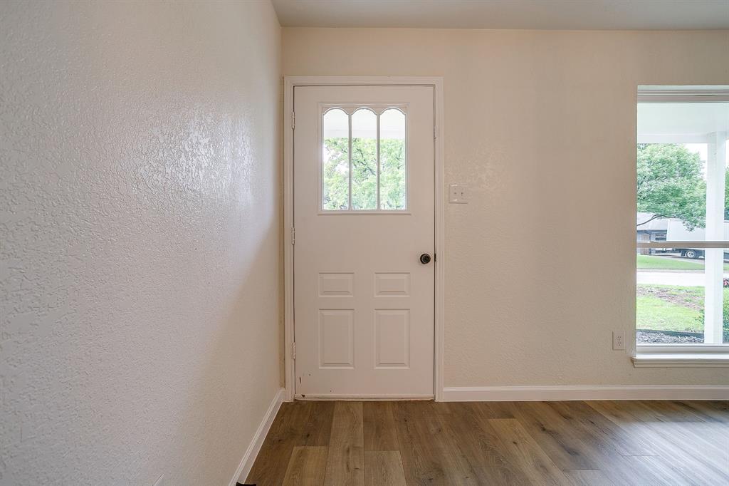 713 Vaughn Drive Burleson, TX 76028 - Photo 9 of 40 an empty room with wooden floor and windows