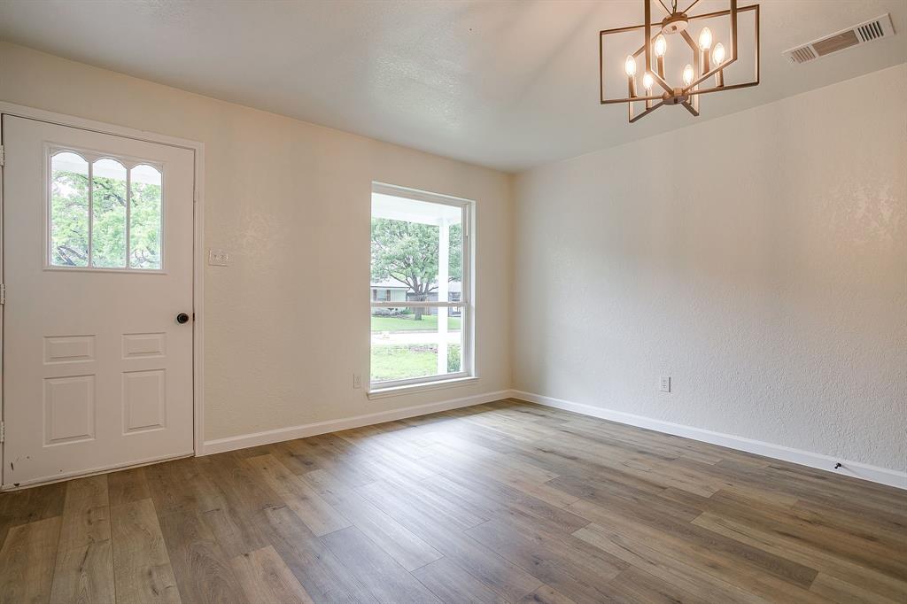 713 Vaughn Drive Burleson, TX 76028 - Photo 10 of 40 an empty room with wooden floor and windows