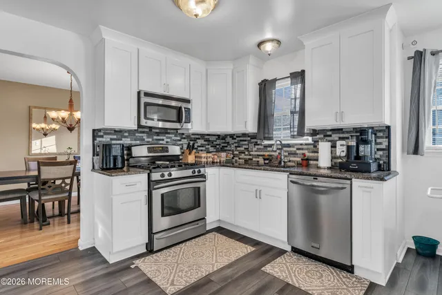 a kitchen with stainless steel appliances a stove a sink cabinets and a refrigerator