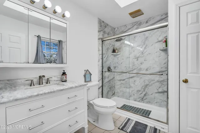 a bathroom with a granite countertop sink toilet and shower