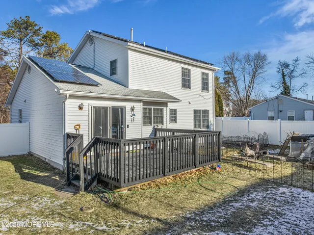 a view of a house with backyard and a tree
