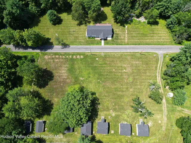 a view of a large pool with lawn chairs under an umbrella