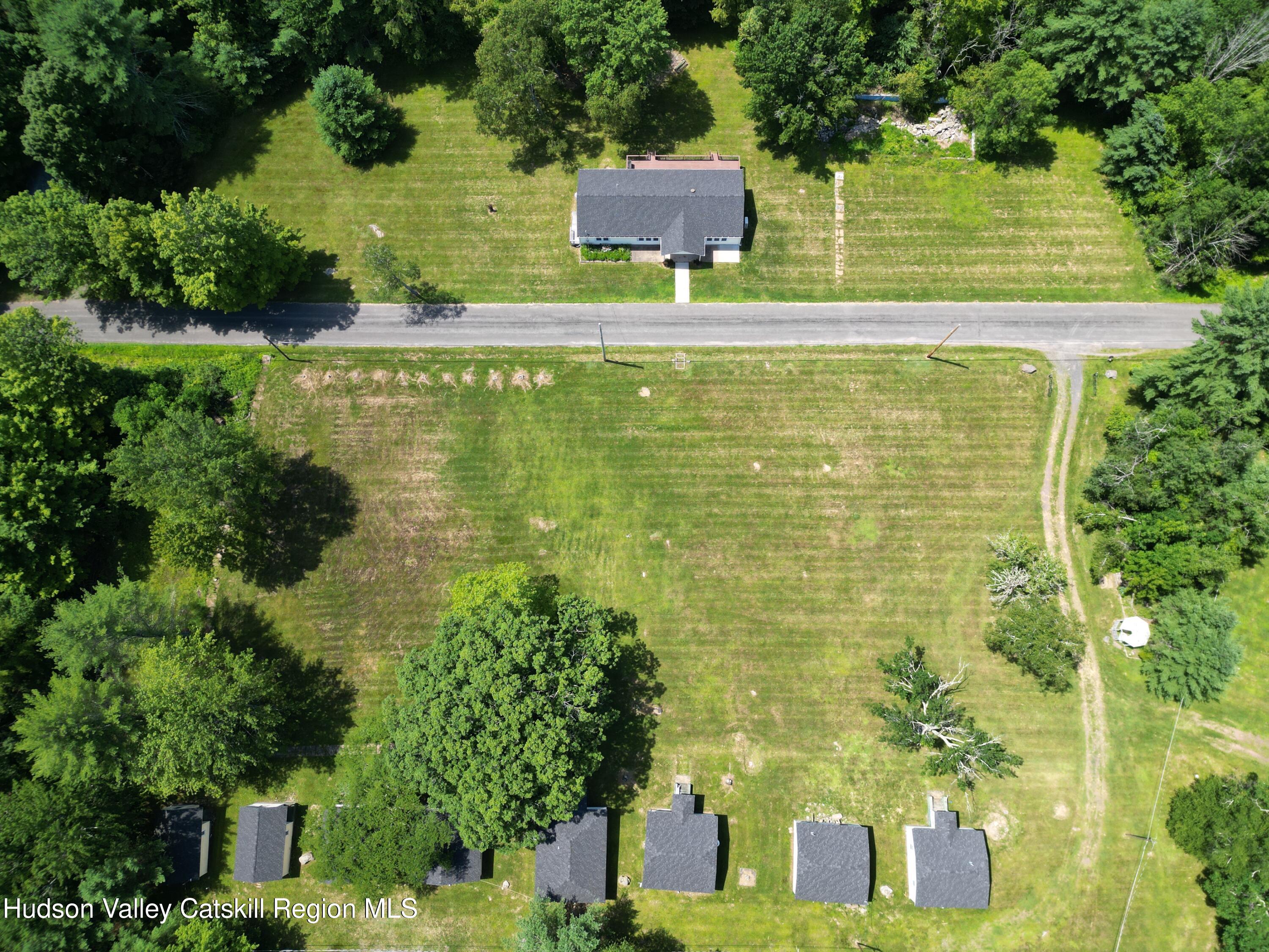 66-84 Katzman Road Ellenville, NY 12428 - Photo 13 of 30 a view of a large pool with lawn chairs under an umbrella