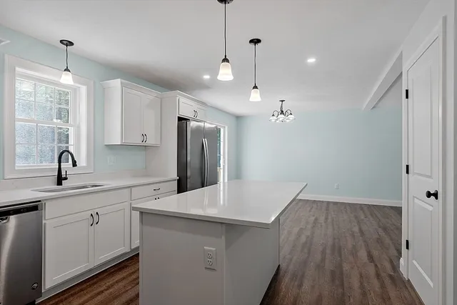 a kitchen with a sink a refrigerator and window