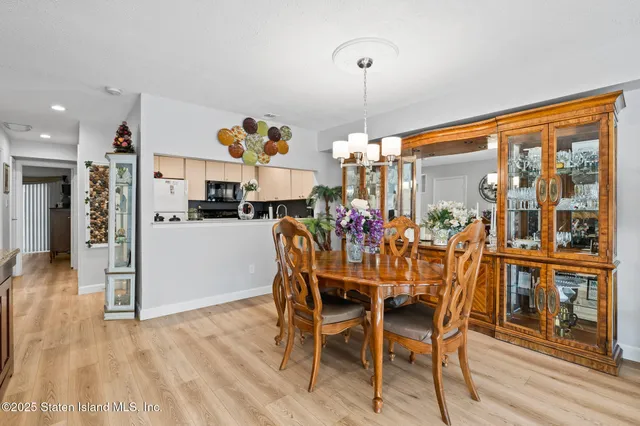a view of a dining room and livingroom with furniture wooden floor a chandelier