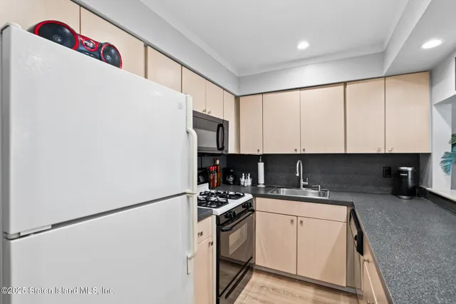a kitchen with a sink a refrigerator and cabinets