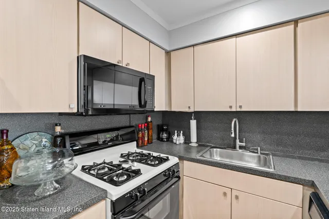 a kitchen with stainless steel appliances granite countertop a sink stove and cabinets