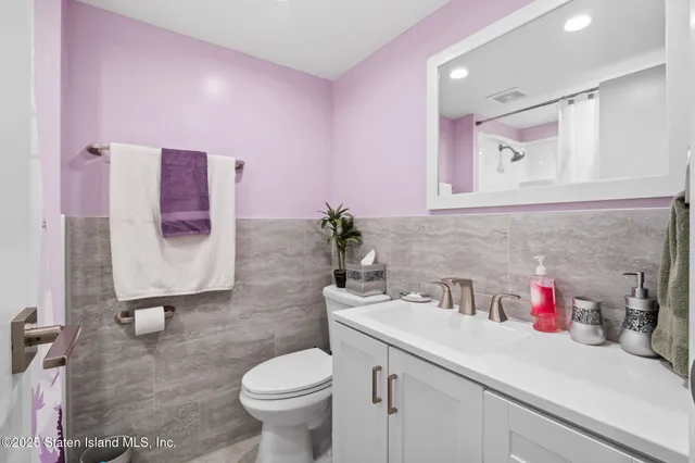 a bathroom with a sink vanity mirror and toilet