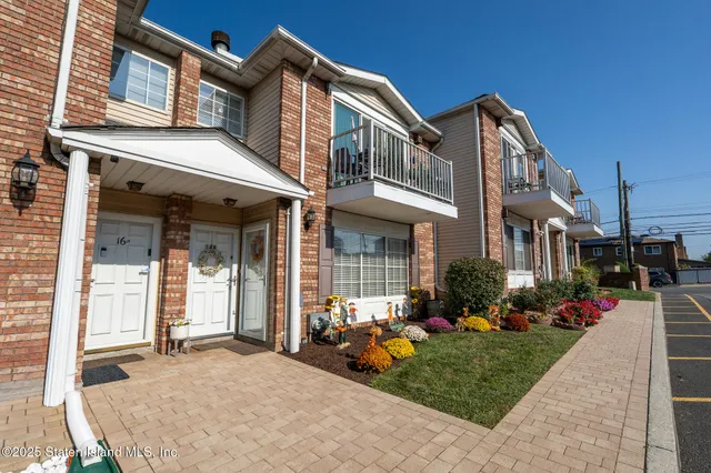 a view of a house with a small yard and potted plants