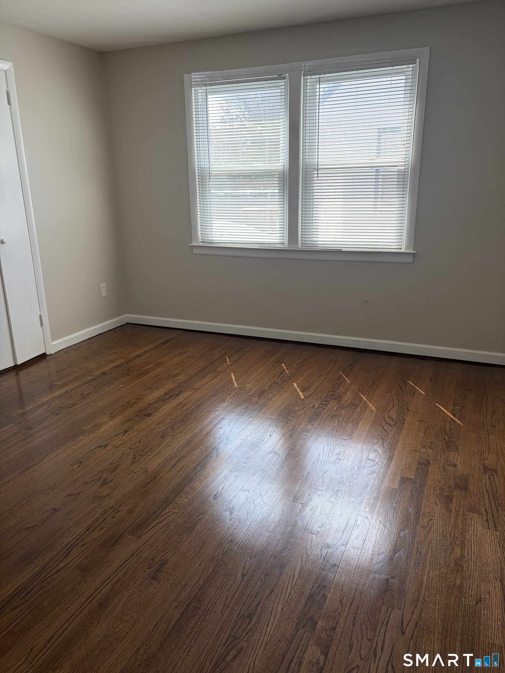 123 Longview Avenue Fairfield, CT 06824 - Photo 11 of 23 an empty room with wooden floor and windows