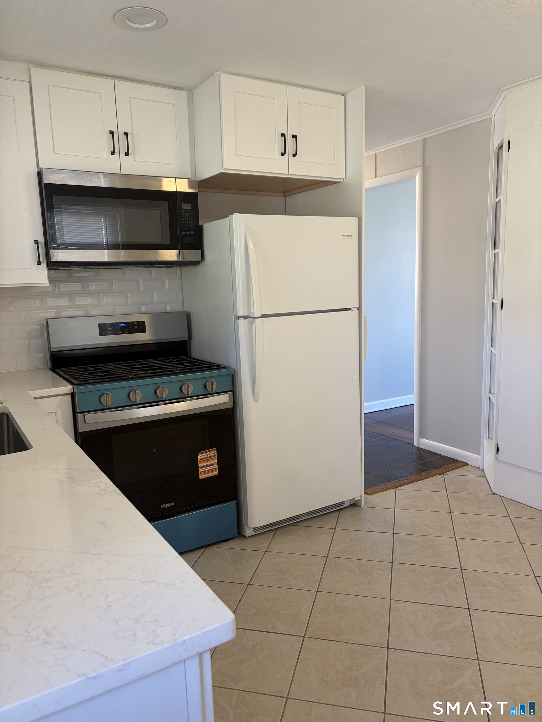 123 Longview Avenue Fairfield, CT 06824 - Photo 6 of 23 a kitchen with a refrigerator a stove top oven and cabinets