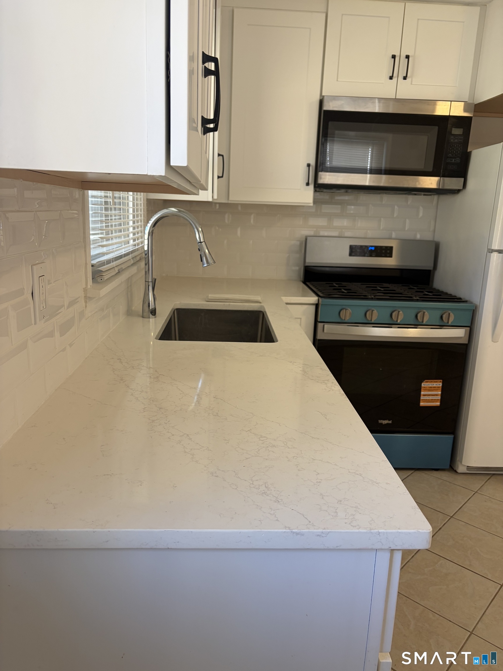 123 Longview Avenue Fairfield, CT 06824 - Photo 7 of 23 a kitchen with a sink a stove and a microwave