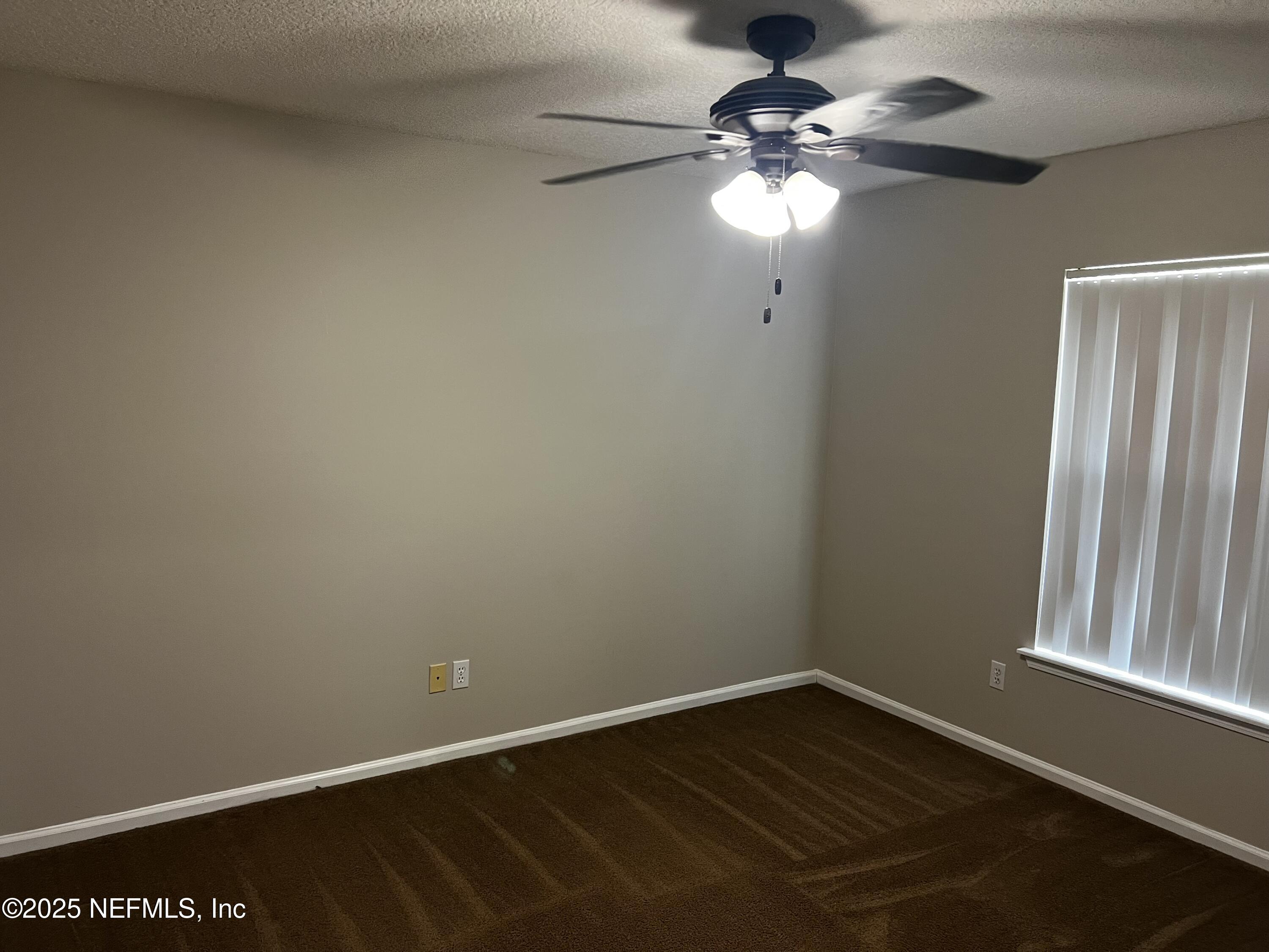 10310 Hamlet Glen Drive Jacksonville, FL 32221 - Photo 20 of 33 a view of an empty room with wooden floor and a window