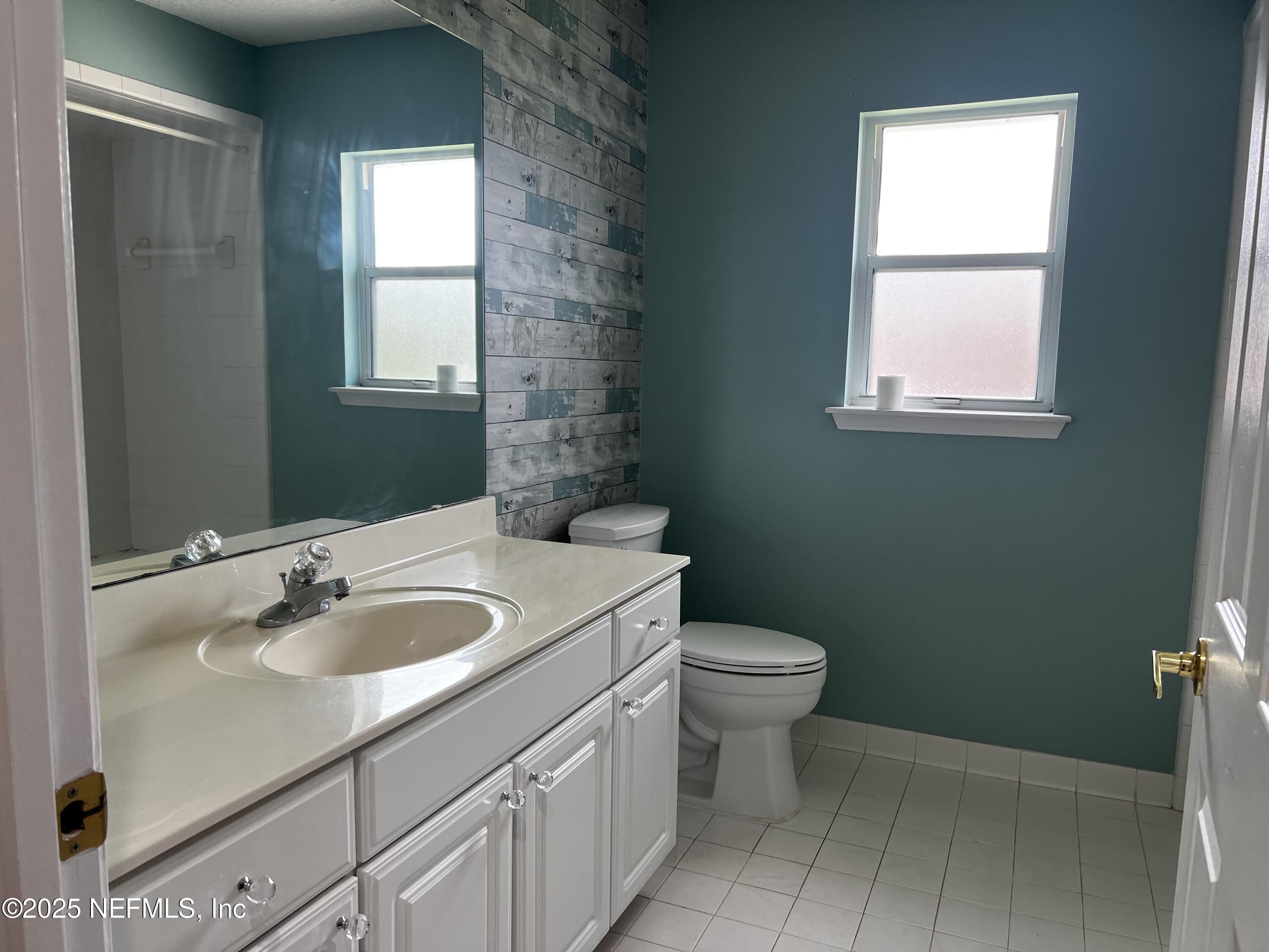 10310 Hamlet Glen Drive Jacksonville, FL 32221 - Photo 21 of 33 a bathroom with a granite countertop sink toilet and mirror