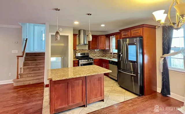 a kitchen with stainless steel appliances granite countertop a refrigerator and a sink