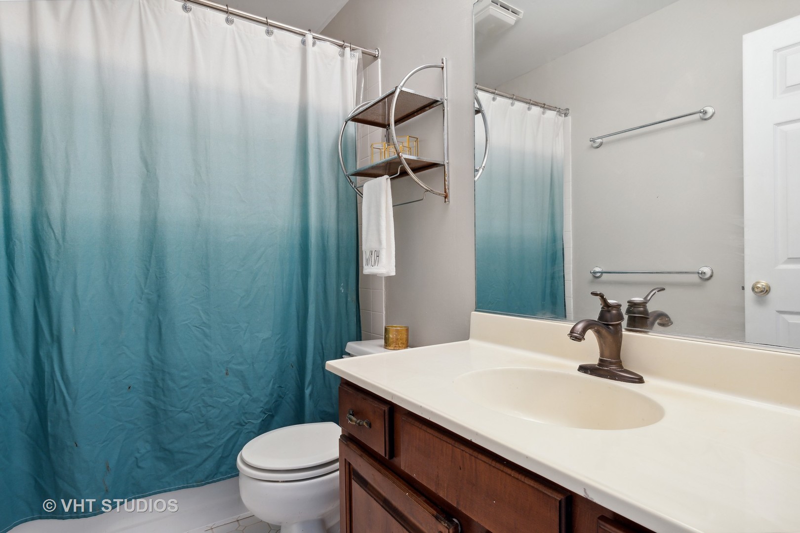 2780 Carriage Way Aurora, IL 60504 - Photo 15 of 19 a bathroom with a sink a toilet a mirror and shower curtain