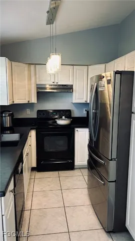a kitchen with granite countertop a refrigerator and a stove