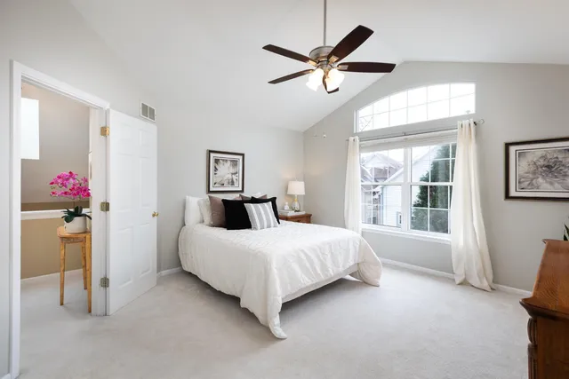 a bedroom with a bed chandelier and a window