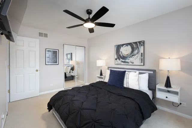 a bedroom with a large bed and a chandelier