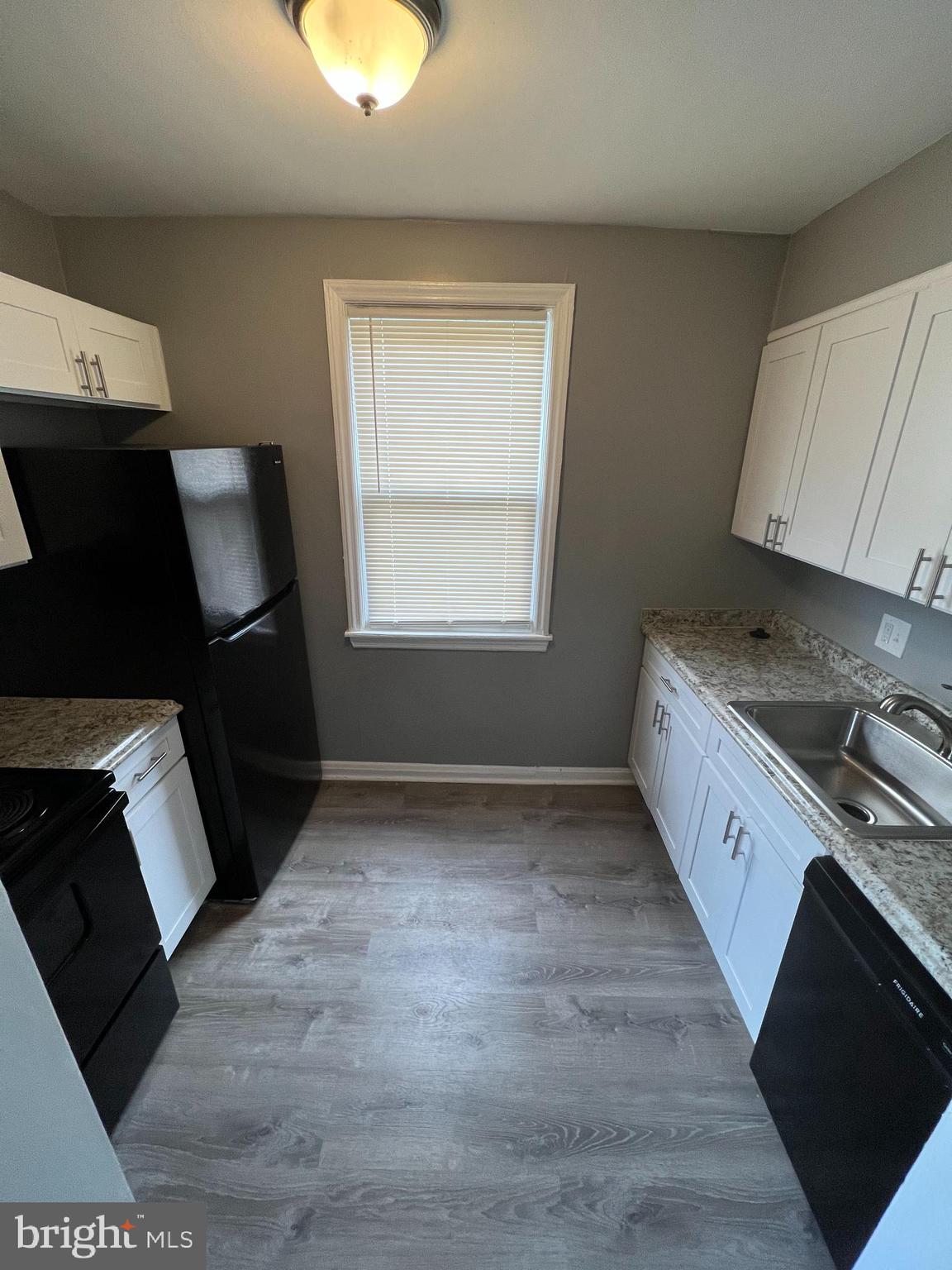 1121 Gleneagle Road Baltimore, MD 21239 - Photo 2 of 17 a kitchen with granite countertop a stove a sink a refrigerator and a microwave