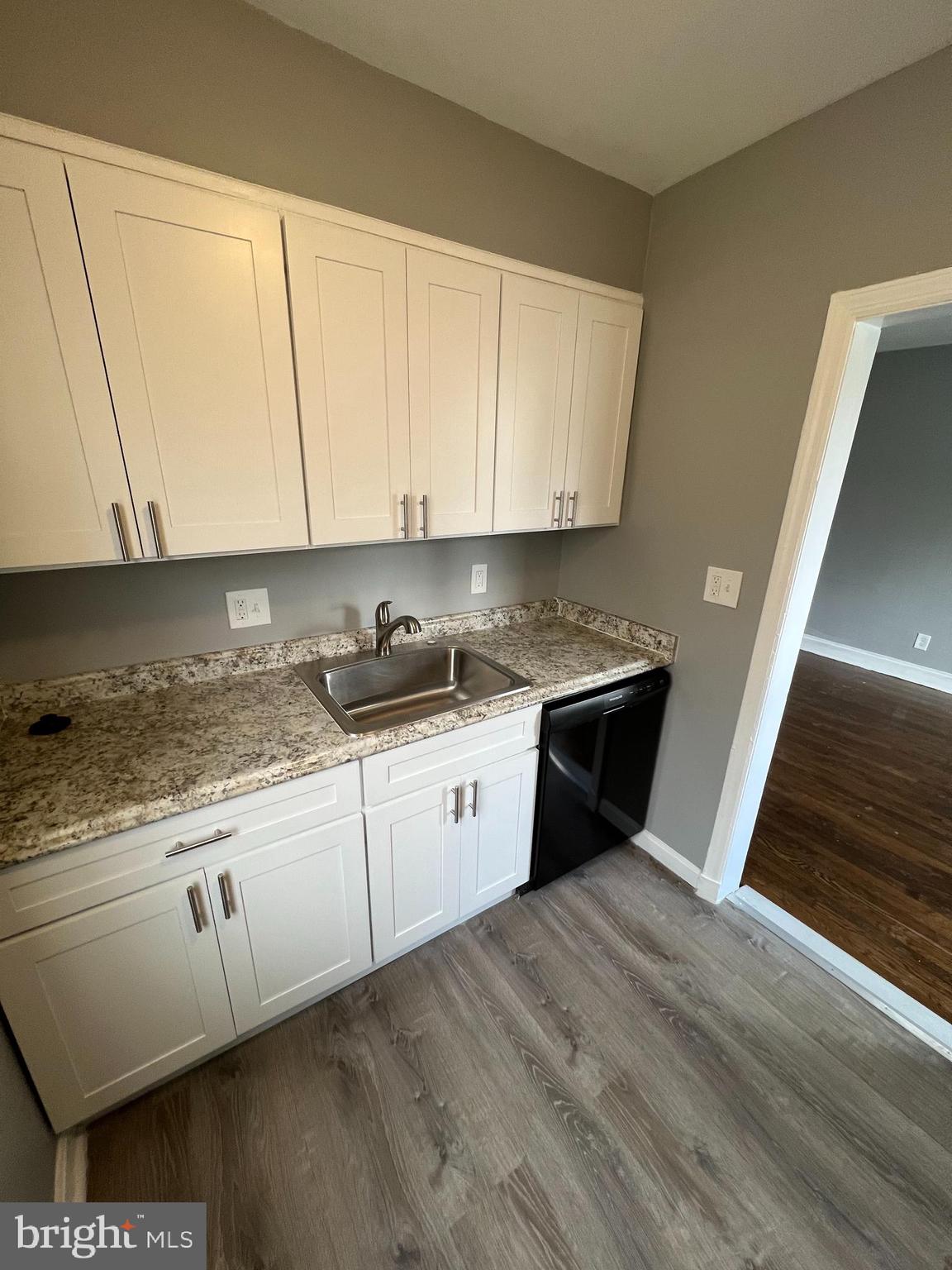 1121 Gleneagle Road Baltimore, MD 21239 - Photo 3 of 17 a kitchen with granite countertop a sink a stove and cabinets