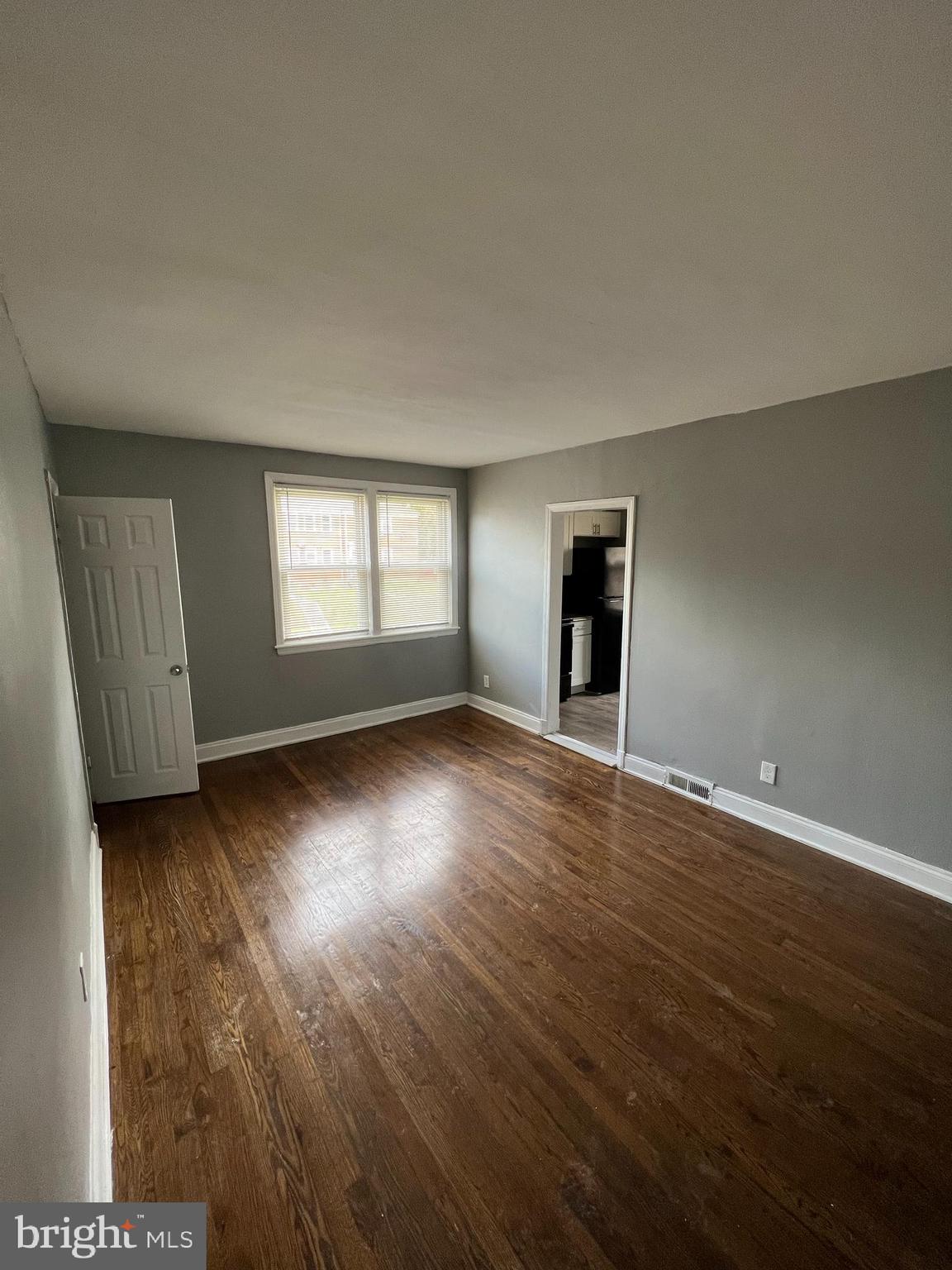 1121 Gleneagle Road Baltimore, MD 21239 - Photo 7 of 17 an empty room with wooden floor and windows