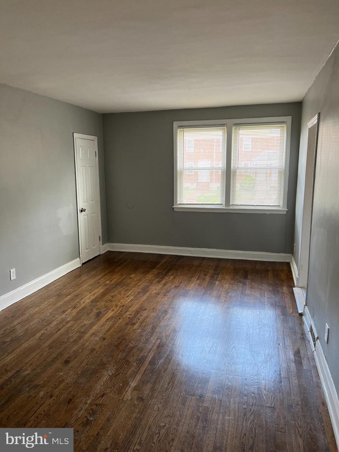 1121 Gleneagle Road Baltimore, MD 21239 - Photo 8 of 17 an empty room with wooden floor and windows