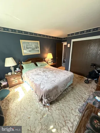 a bedroom with a bed and teddy bear on bed