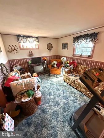 a living room with furniture chess board and a window