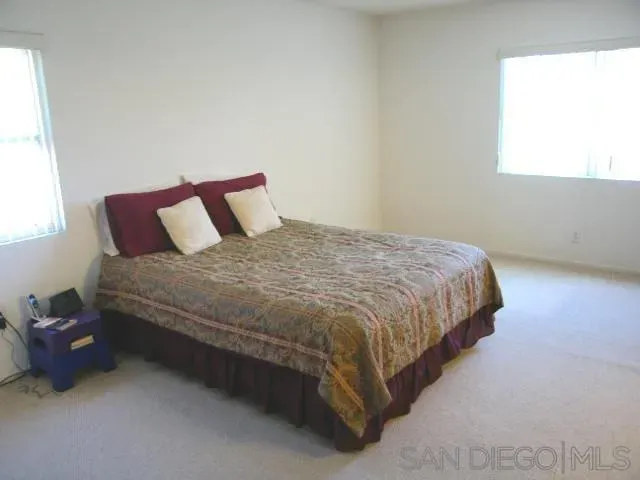 a large bed sitting in a bedroom next to a window