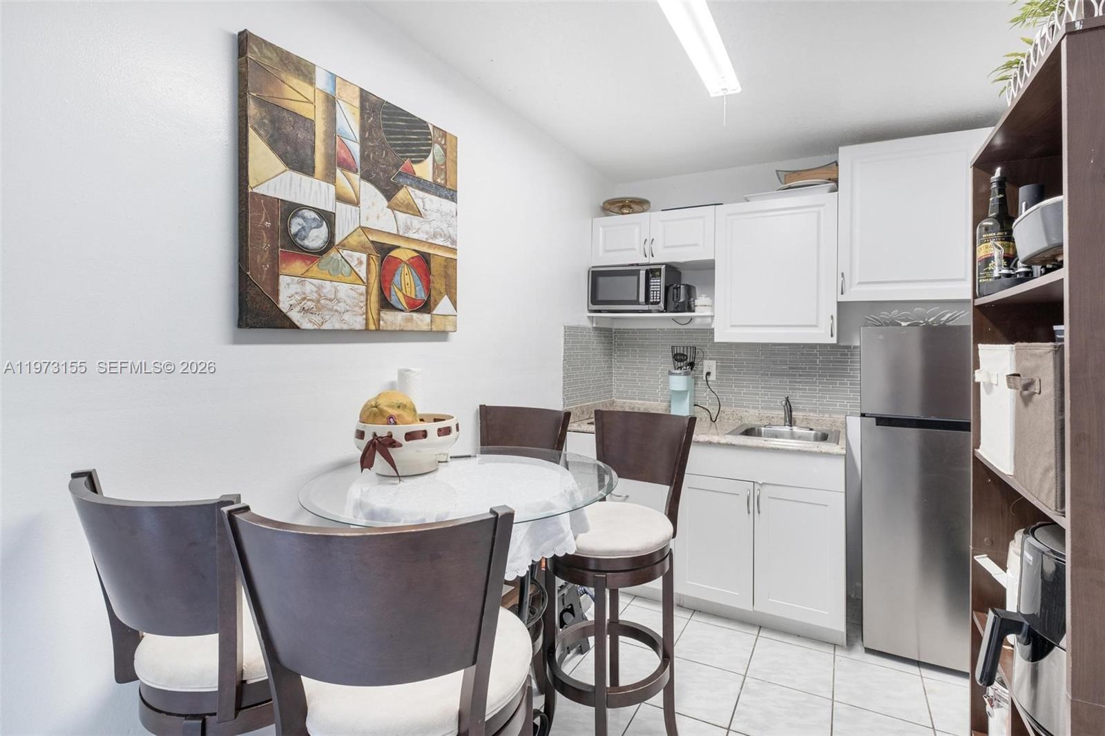 13710 Southwest 18th Terrace Miami, FL 33175 - Photo 23 of 46 a kitchen with stainless steel appliances a dining table and chairs