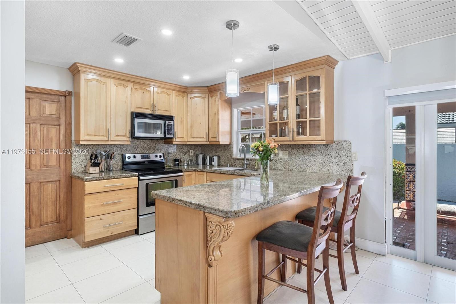 13710 Southwest 18th Terrace Miami, FL 33175 - Photo 10 of 46 a kitchen with granite countertop a stove top oven a sink a dining table and chairs