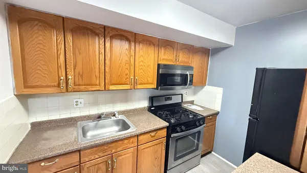 a kitchen with stainless steel appliances granite countertop a refrigerator and a stove