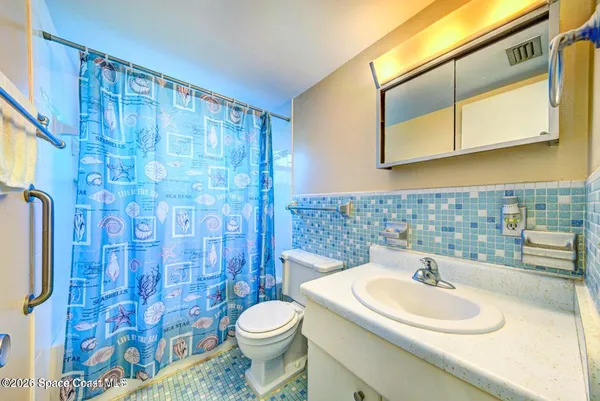 a bathroom with a sink a toilet and shower curtain