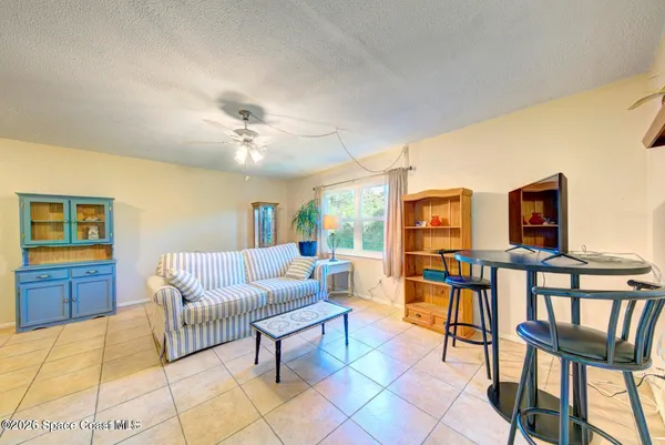 a living room with furniture and a ceiling fan
