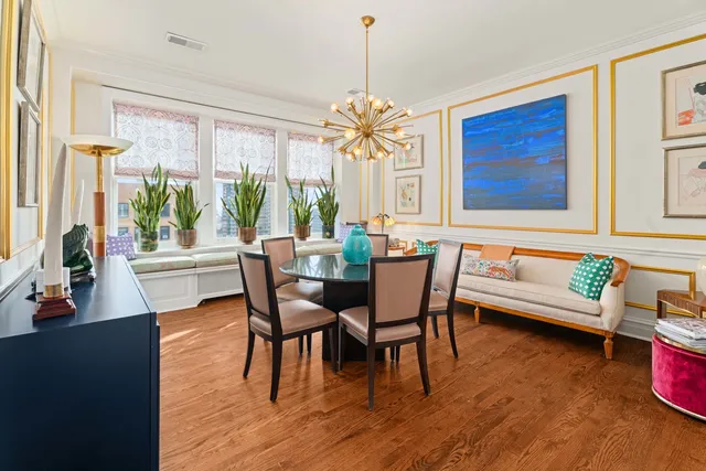 a dining room with furniture potted plants and wooden floor