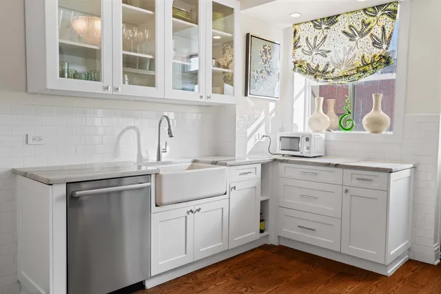 a kitchen with stainless steel appliances white cabinets and a window