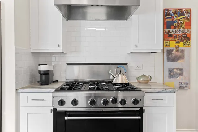 a stove top oven sitting inside of a kitchen
