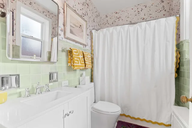 a bathroom with a sink a toilet and a mirror