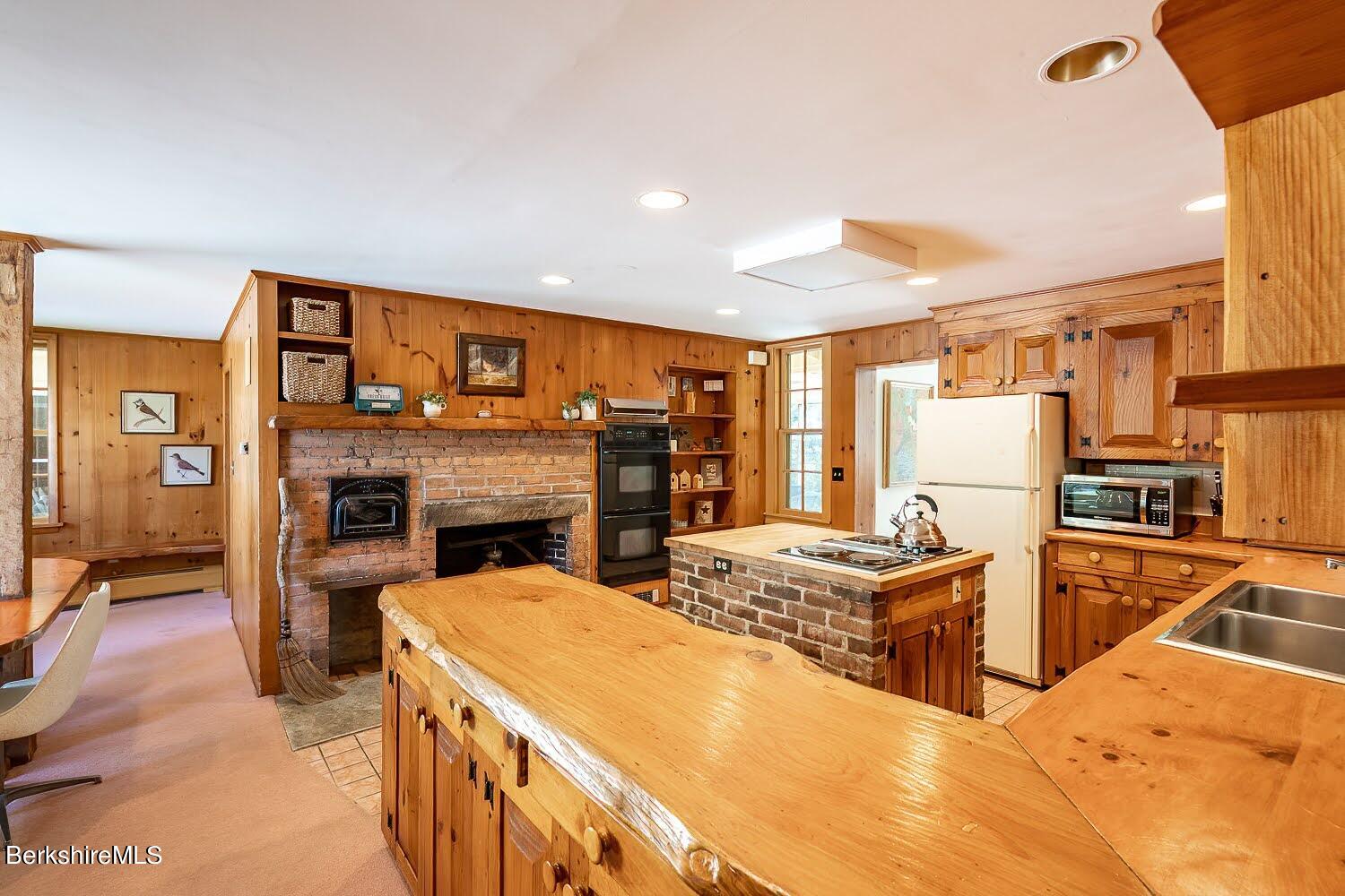 39 Main Street Stockbridge, MA 01262 - Photo 12 of 39 a kitchen with stainless steel appliances granite countertop a stove refrigerator and a fireplace