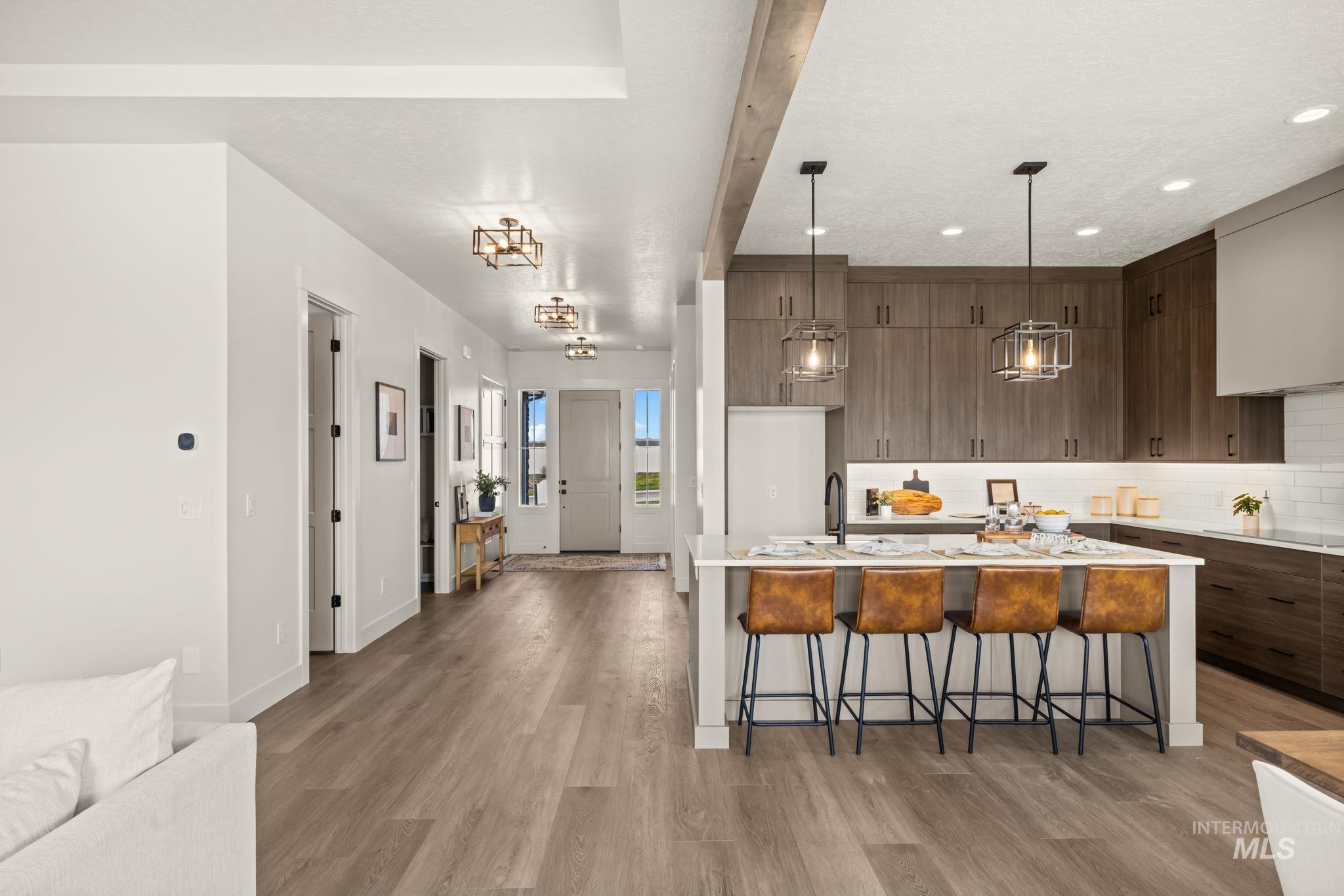 345 South Strut Way Boise, ID 83716 - Photo 23 of 50 Modern kitchen featuring a large island with seating, dark wood-finish cabinetry, white subway tile backsplash, and recessed lighting