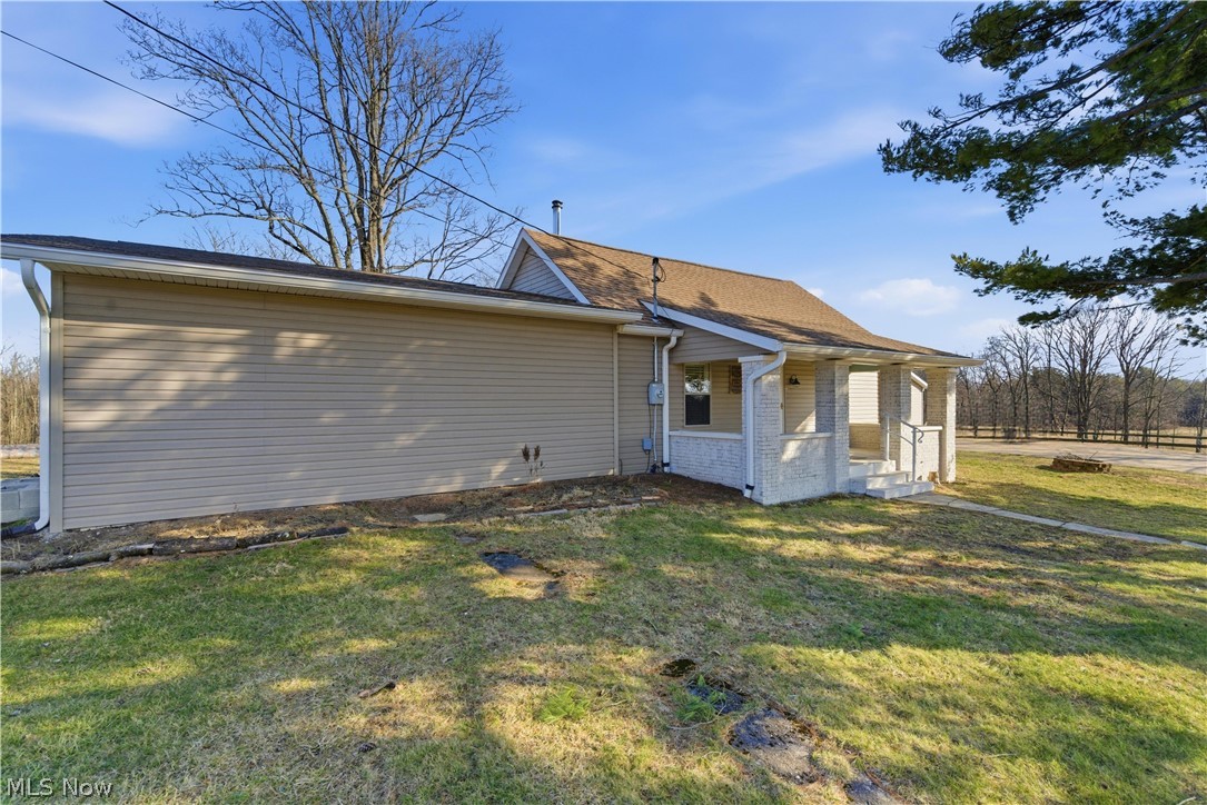52450 Tower Road Cumberland, OH 43732 - Photo 26 of 41 Rear view of house featuring a lawn and brick siding