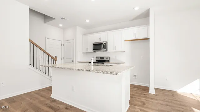 a kitchen with stainless steel appliances granite countertop a sink and a stove