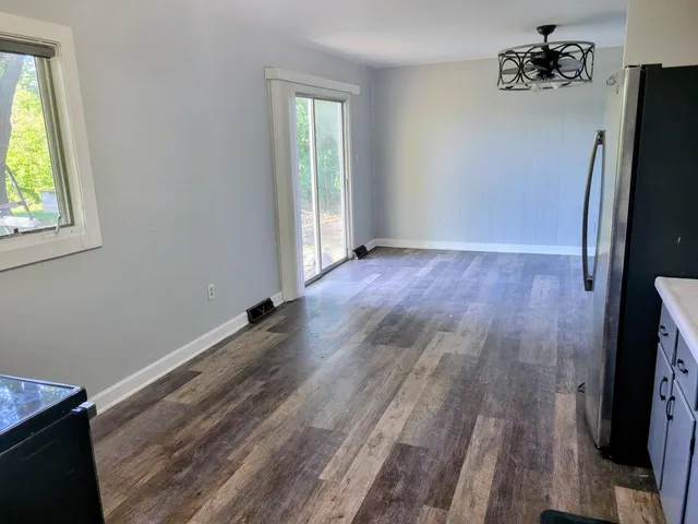 a view of a livingroom with wooden floor and a window