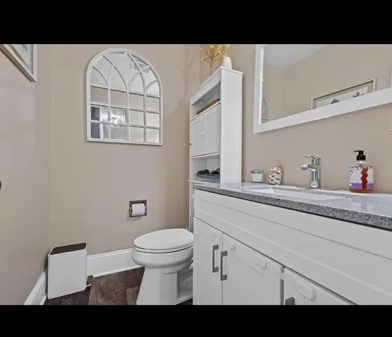 a bathroom with a toilet a sink and mirror