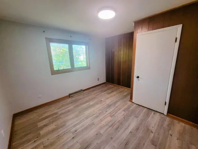 an empty room with wooden floor and a window