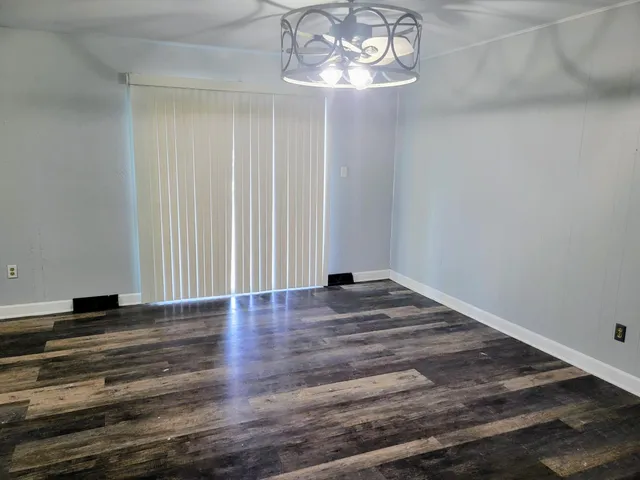 a view of empty room with wooden floor and window