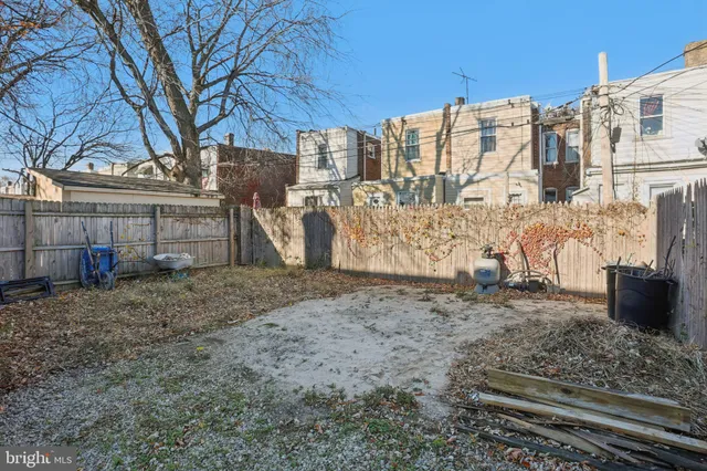 a view of a dry yard with wooden fence