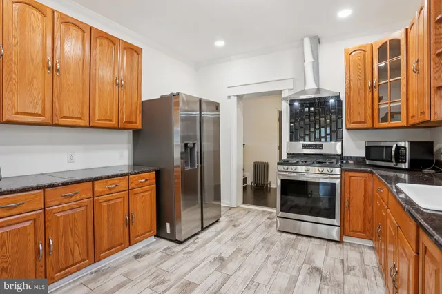 a kitchen with stainless steel appliances granite countertop a refrigerator and a stove top oven