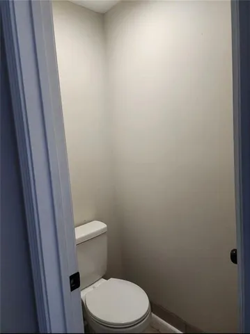 a white toilet sitting next to a shower